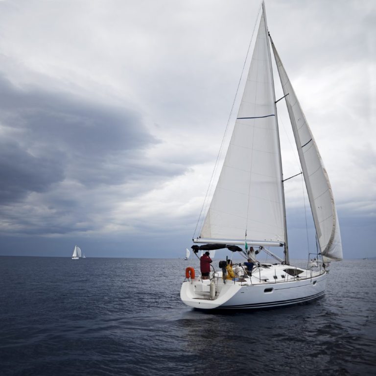 Sailing boat A sailing boat with both sails up sailing on a cloudy day.